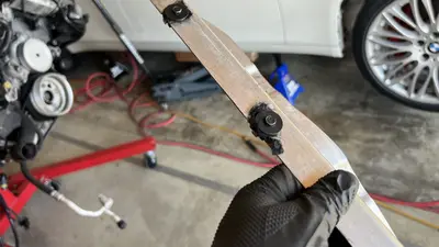 Thin heat-shield strip with felt washers — fastener type for bay reassembly.