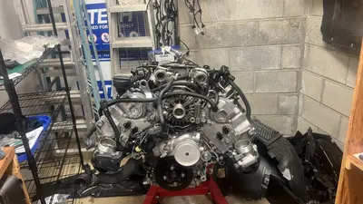 Front of the long block — black crank pulley visible, balancer bolt still pending.