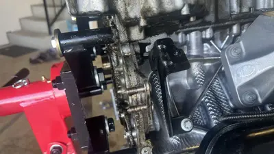 On the stand: mount arms bolted into the rear of the long block — ready for teardown.