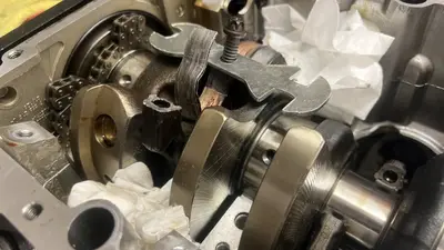Bottom end open: failed bearing shell still in the case, timing chain on the left, towels catching debris.