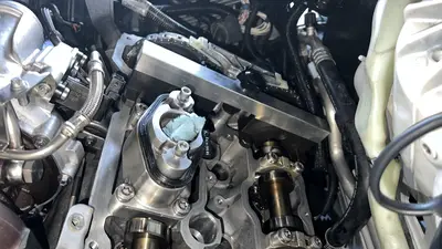 Bank 1 with the valve cover off: cam timing block bolted across the cams, chain and VANOS gears visible.