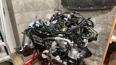 Rear three-quarter of the dressed long block — plumbing and electrics in place.