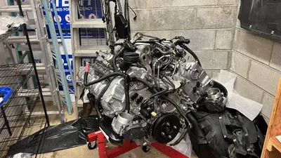 Wiring and fuel lines going on — long block filling out on the stand.
