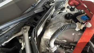 Underbody view — oil pan fasteners and nearby sensors.