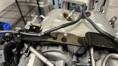 Arch bracket over the turbos — not the valve covers.