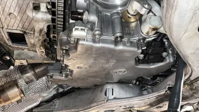 Oil pan from below — level sensor, Torx perimeter, and flywheel edge.