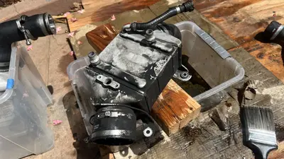 Oil cooler off the car for a solvent scrub — still coated in oil film.