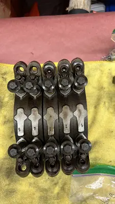 Main caps 1–5 with bolts, kept in order after coming off the block.