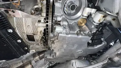 Close-up under the car — oil pan (7 570 091) meeting the bellhousing.