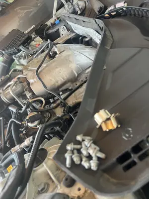 Hardware staged on the cowl while the heat shield stays put — top-end still mostly dressed.